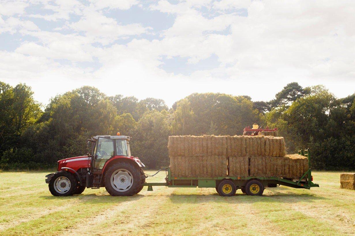 Farm tractor rental in Ohio transporting hay on rural land