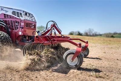 Ohio lawn pro attaching landscape rake to tractor in field
