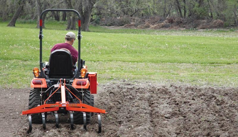 Ohio farmer operating compact tractor with tiller in rental field